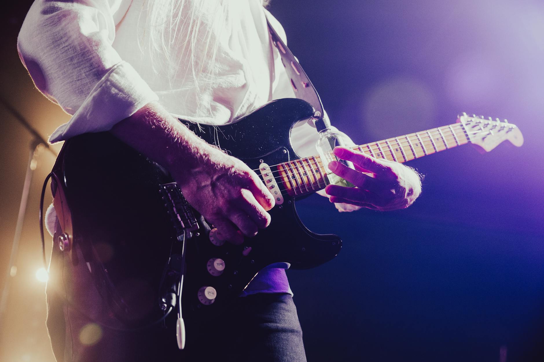 Musician playing an electric guitar on stage
